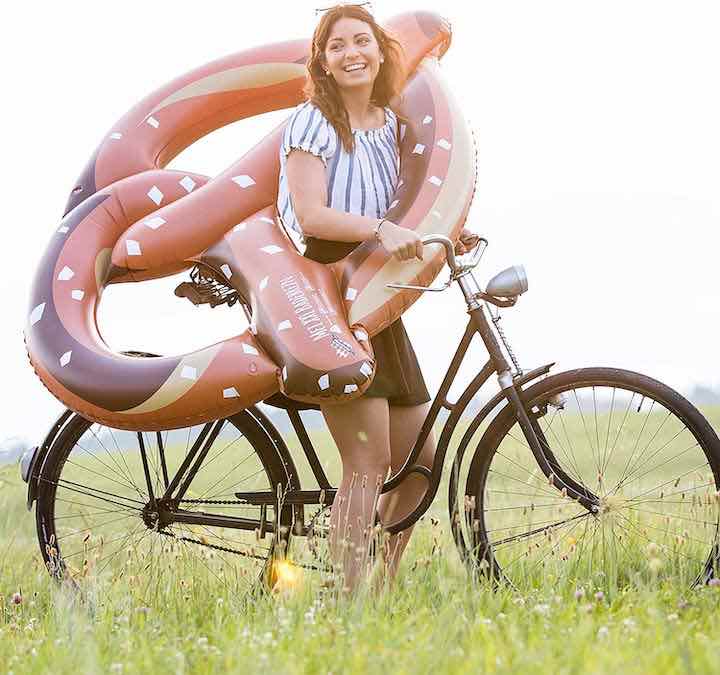 aufblasbare-Schwimmbrezel-auf-dem-Fahrrad-mit-Frau