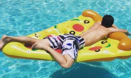 aufblasbares Pizza Stueck im Pool mit Mann